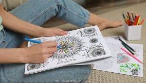 Close-up of an adult coloring a detailed mandala with colored pencils, promoting focus and mindfulness.