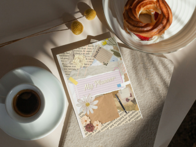 My Weekly Planner Journal cover on a desk with coffee and pastry in a cozy lifestyle setting