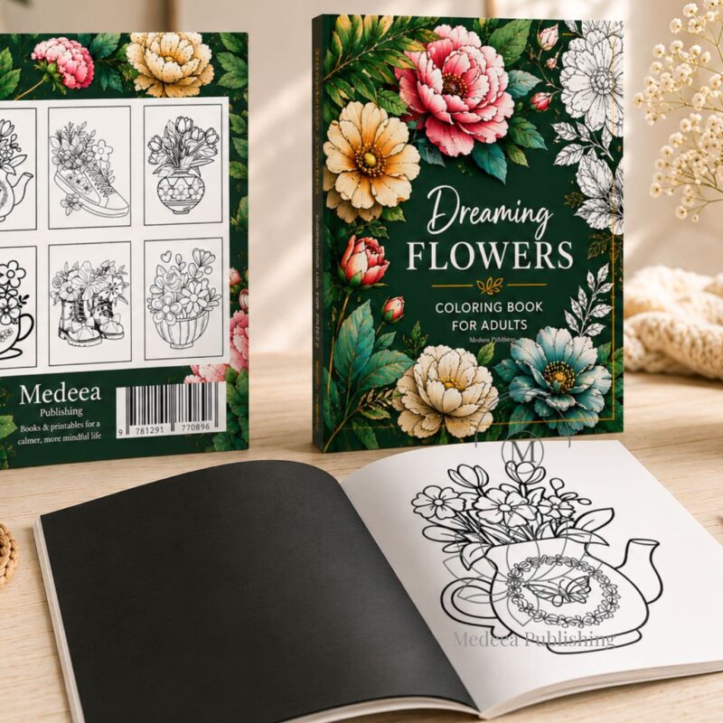 Flowers coloring book displayed in a cozy lifestyle setting with front cover, back cover, and open interior pages on a wooden table