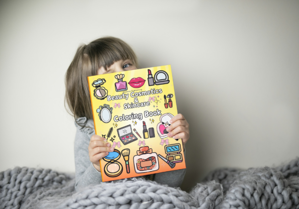 Gifting the Beauty Cosmetics Coloring Book A young girl holding the Beauty Cosmetics Coloring Book by Medeea Publishing.