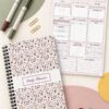 Daily Planner Modern Terrazzo Edition shown in a coil-bound format beside an interior planning page, colorful markers, gold paper clips, and decorative accents.