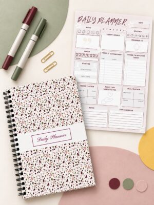 Daily Planner Modern Terrazzo Edition shown in a coil-bound format beside an interior planning page, colorful markers, gold paper clips, and decorative accents.