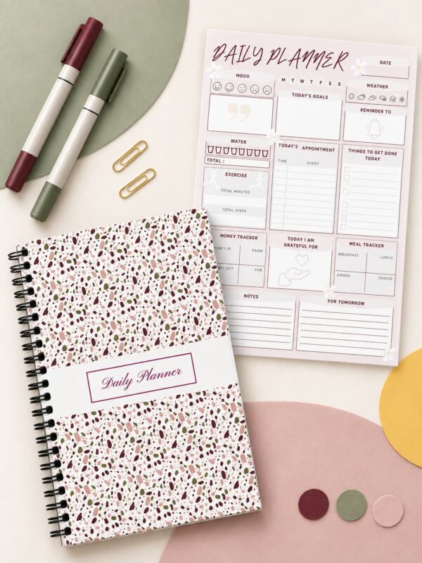 Daily Planner – Coil-Bound Planner and Interior Page Daily Planner Modern Terrazzo Edition shown in a coil-bound format beside an interior planning page, colorful markers, gold paper clips, and decorative accents.